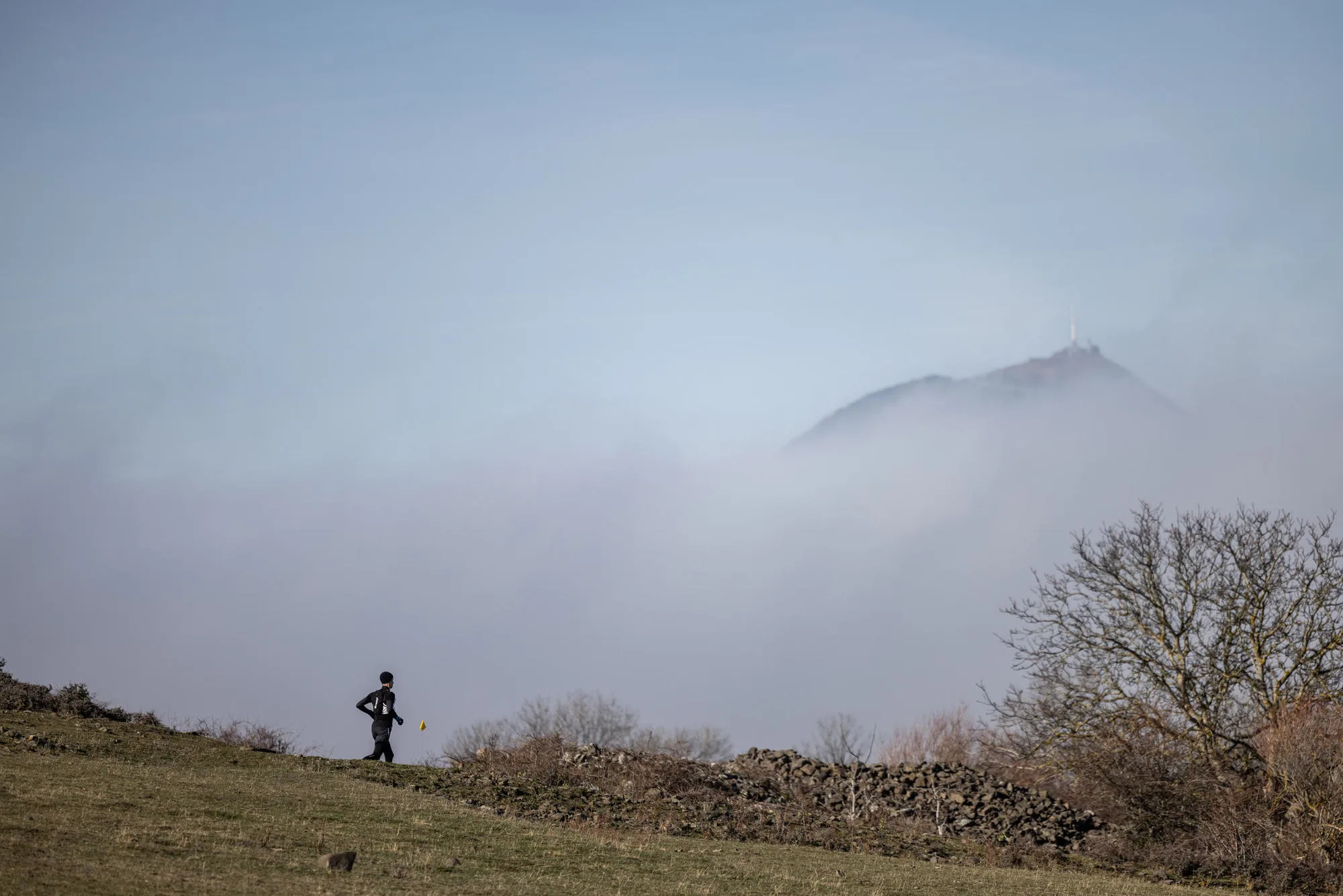 Coureur solitaire de La Romagnatoise face au puy de Dôme émergeant de la brume